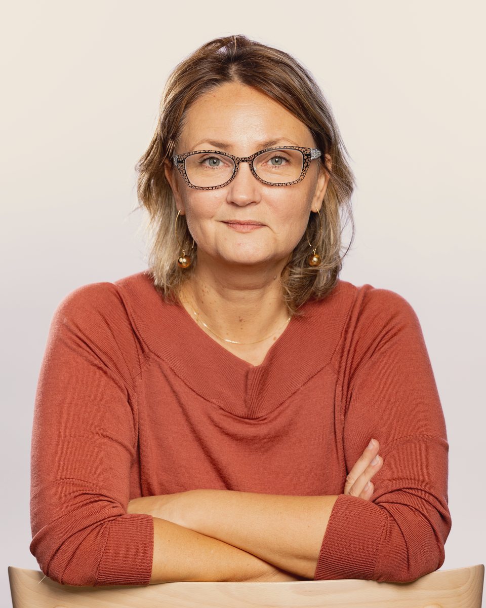 Caroline Maillols, founder of Pace to Value, seated with her arms resting on the back of a wooden chair